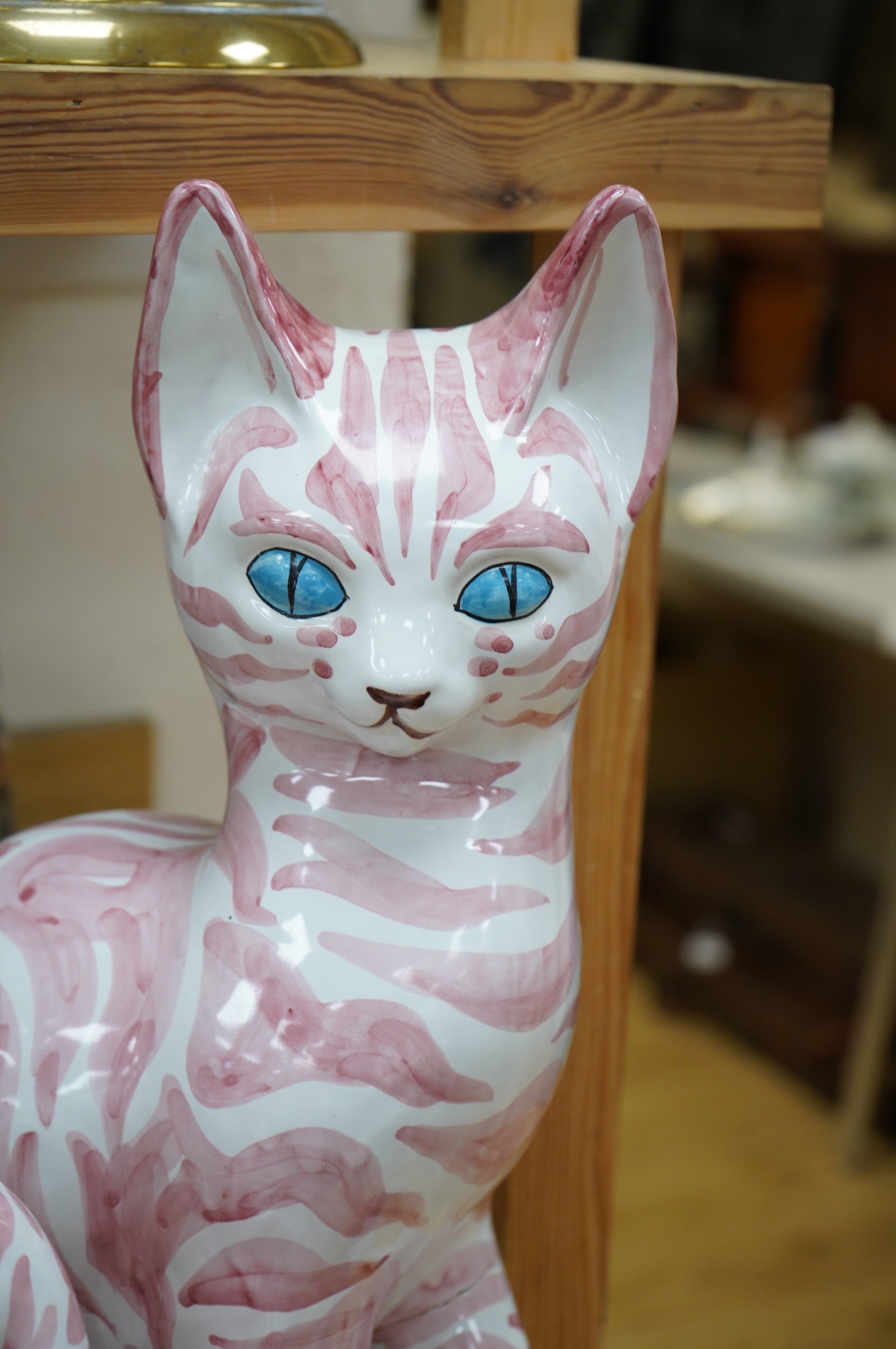 A large 1950's Italian pink maiolica seated cat and two smaller, largest 45cm. Condition - poor